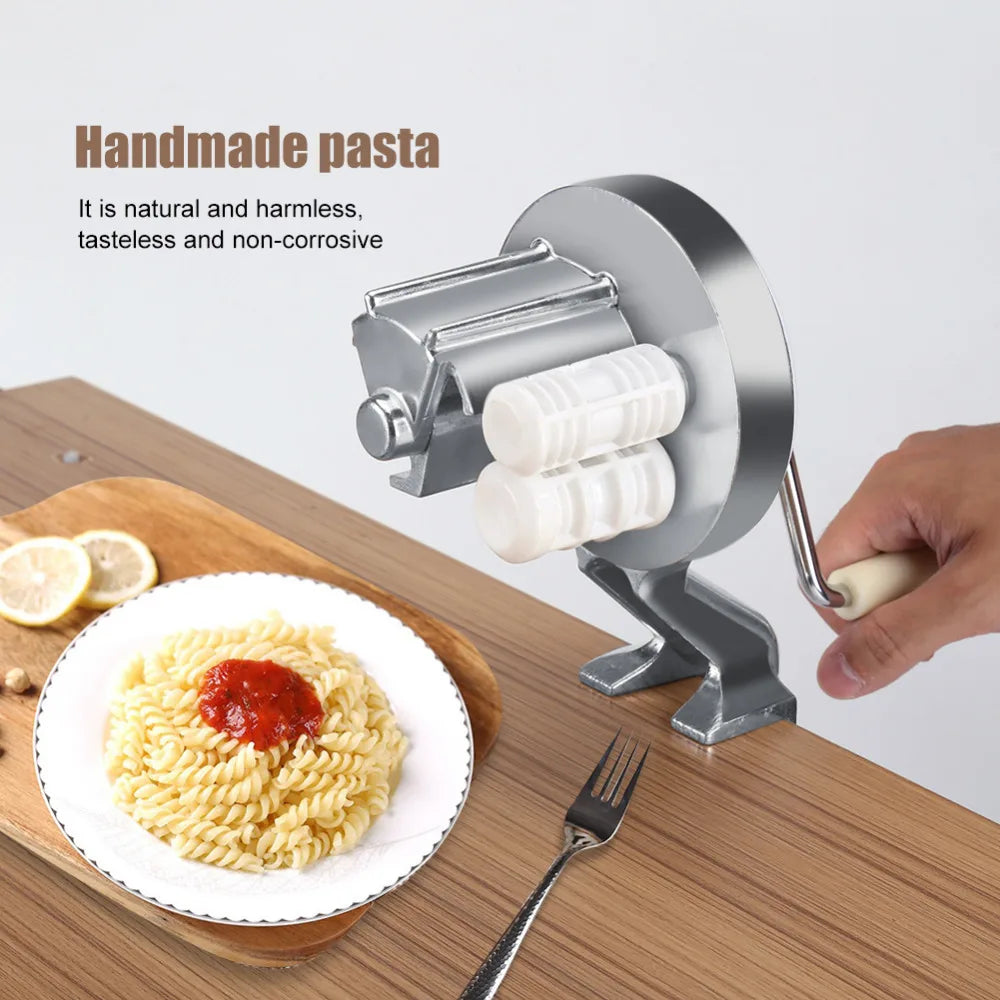 A person uses a Soulful Trading Cavatelli Pasta Maker to extrude fresh, homemade pasta onto a white plate, which already holds a serving of pasta topped with tomato sauce; ingredients like lemon slices are visible nearby.