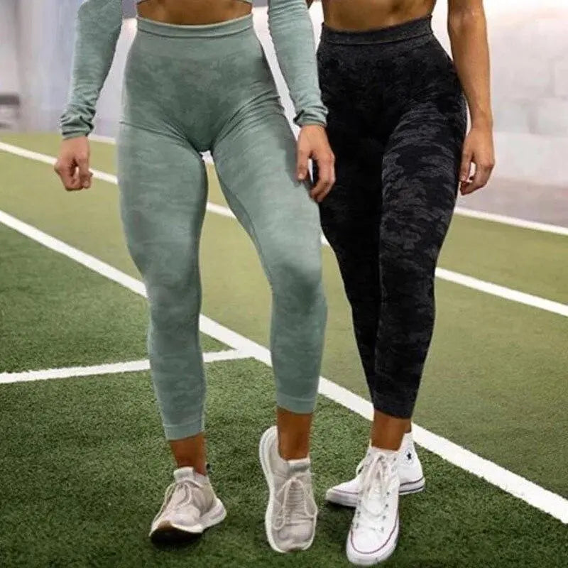Two women standing on a green turf, cropped at torso, wearing Fitness-8 seamless high waist leggings and sneakers, ready for a workout.