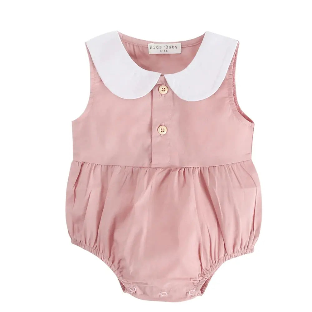 A pink Spring &amp; Summer Baby Onesie with a white peter pan collar, featuring two buttons at the chest and elasticated leg openings, displayed on a white background by Soulful Trading.
