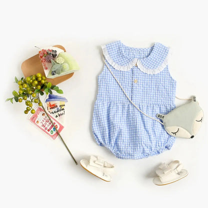 Flat lay of high-quality Spring &amp; Summer Baby Onesie from Soulful Trading, white shoes, a sleep mask, and a decorative branch, with greeting cards on a white background.