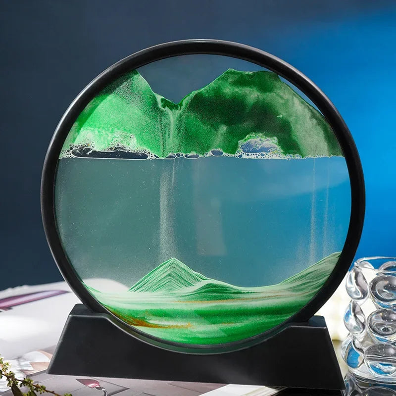 Circular frame displaying a green and blue colored Soulful Trading 3D Moving Sandscape depicting a mountain landscape, set on a black stand with a blue background.