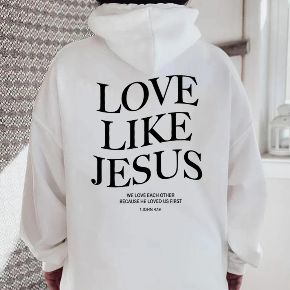 Person wearing a Soulful Trading Love Like Jesus Christian Sweatshirt with the text &quot;love like Jesus&quot; and &quot;we love each other because he loved us first - 1 John 4:19&quot; printed on the back.