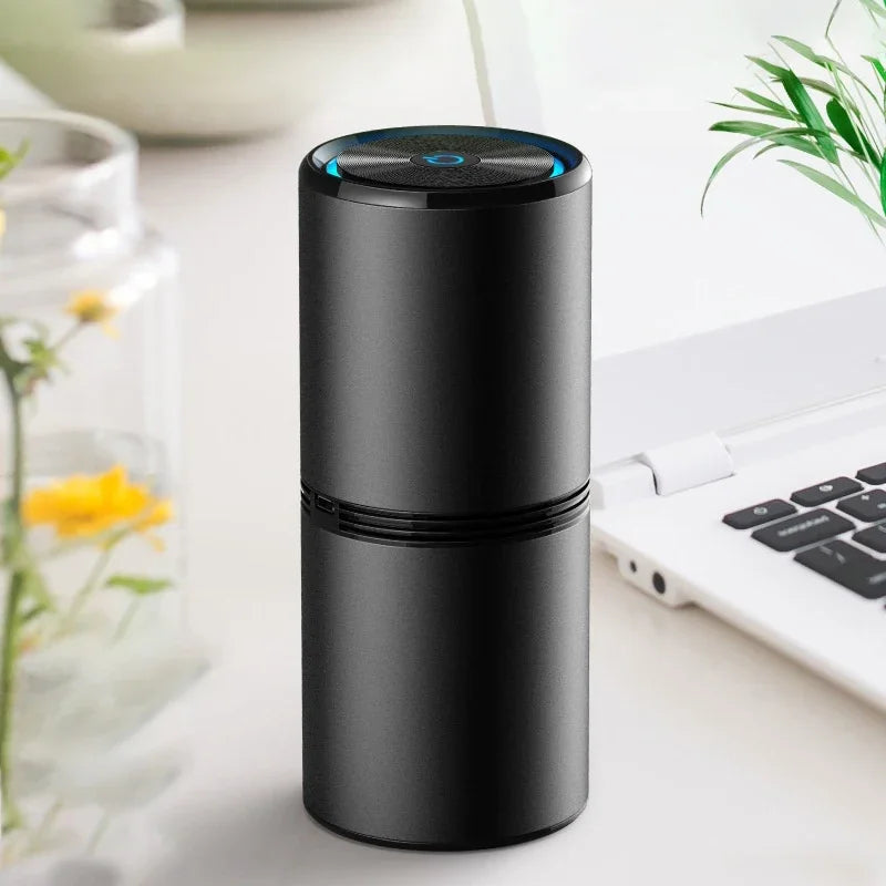 A sleek black Soulful Trading Ionic Air Purifier designed to remove viruses and bacteria, standing on a desk next to a laptop, with a digital interface on top.