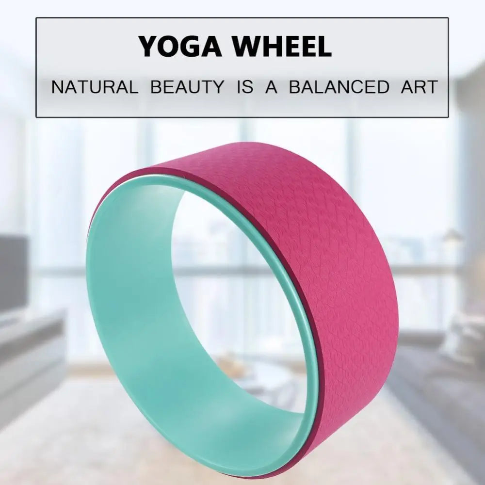 A Fitness-8 Yoga Pilates Circle Wheel with pink outer and teal inner surfaces, positioned in front of a blurred indoor background. Text above reads &quot;Yoga Pilates Circle Wheel - natural beauty is a balanced art